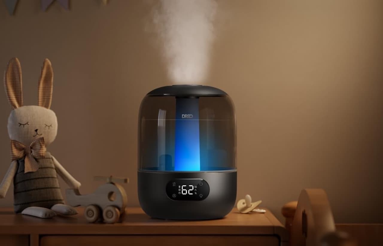 Un humidificateur d'air Dreo posé sur une commode dans une chambre de bébé le soir.