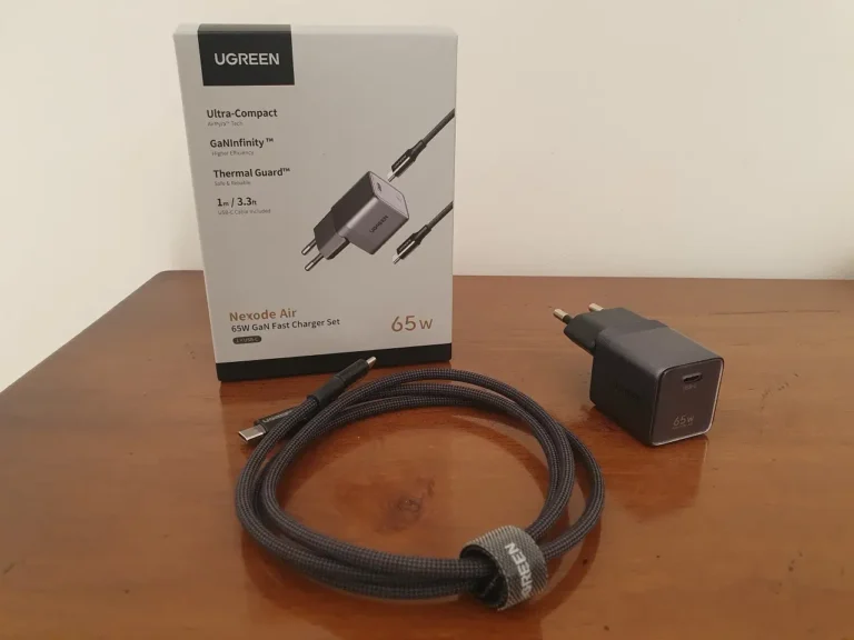 La boite du chargeur Ugreen Nexode Air 65W et son contenu étalé sur une table.