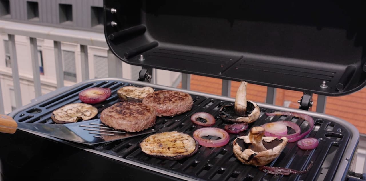 Zoom sur de la nourriture en train de cuire sur un barbecue électrique de la marque Campingaz.