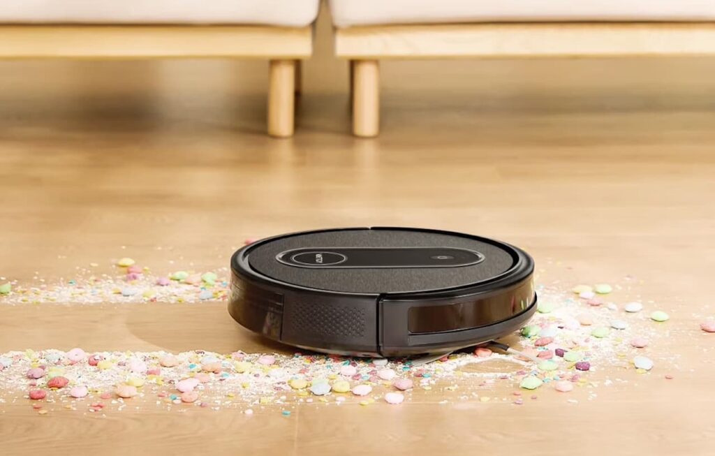 Un robot aspirateur de la marque Vactidy qui nettoie le parquet d'un salon lumineux.