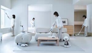 Une femme qui utilise un aspirateur de la marque SwitchBot pour nettoyer une pièce à vivre lumineuse.